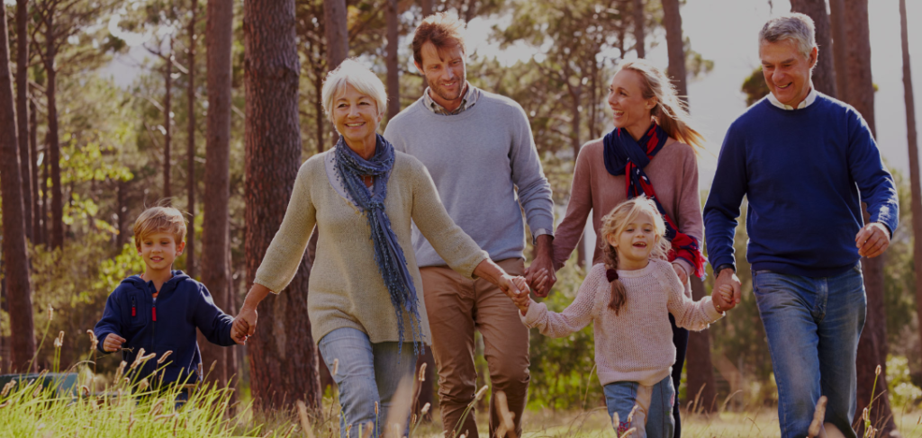 Happy, healthy family holding hands walking on a trail