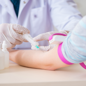 Doctor drawing blood from patient's arm